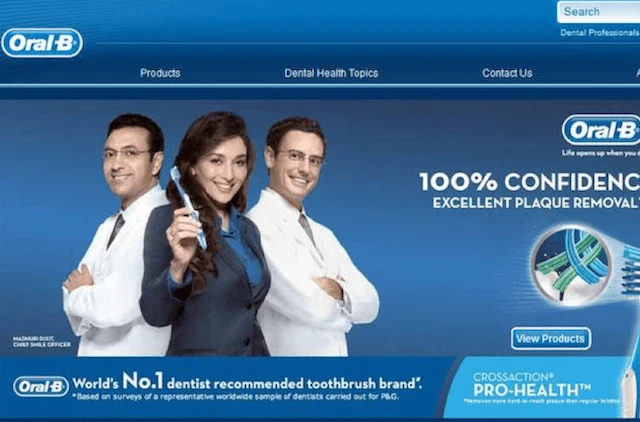 Oral-B advertisement showing three smiling professionals, two in lab coats, one holding a toothbrush, promoting the brand. An example of psychology of advertising.