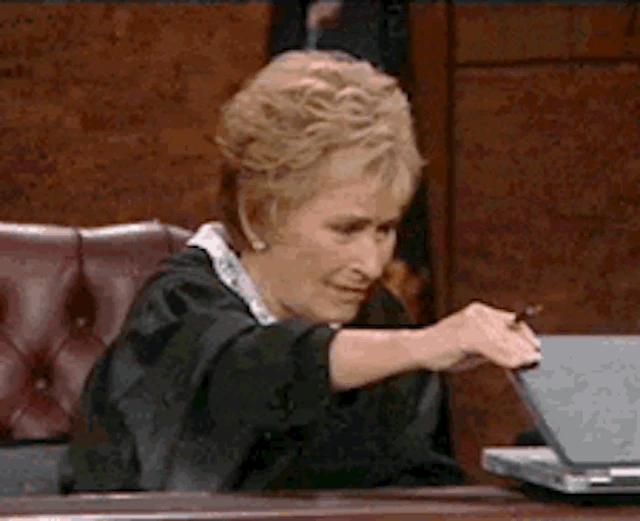 A woman in a black robe, Judge Judy, humorously closes a laptop with a pen during a discussion about what is lead generation in digital marketing.