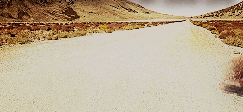 Long, empty desert road stretching towards distant mountains under a vast sky, symbolizing a journey or path forward with an SEO consultant.