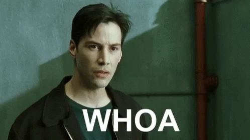 Keanu Reeves, as Neo, looking surprised with the word 'WHOA' on the screen.