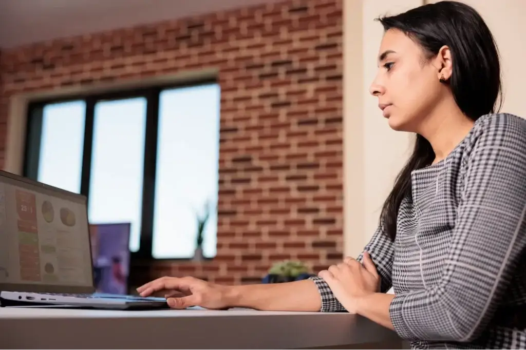 freelancer analysing business charts on a laptop to optimise cpa in digital marketing strategies.