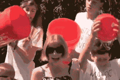 People pouring red buckets of ice water over their heads for the ALS Ice Bucket Challenge, a viral emotional contagion event.